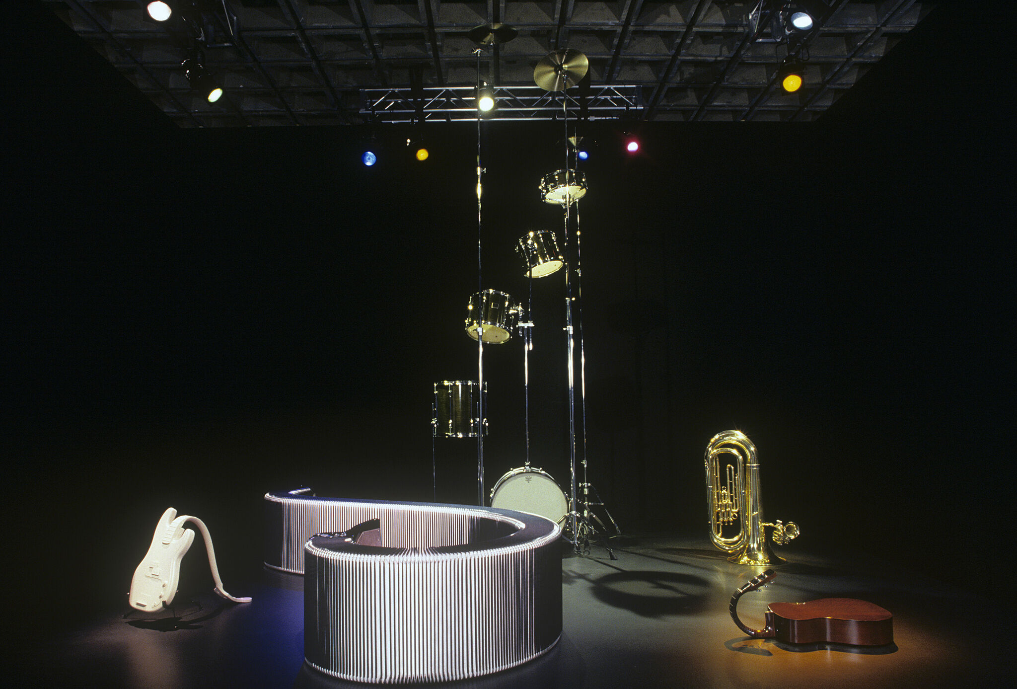 A dark gallery with sculptures of various musical instruments.