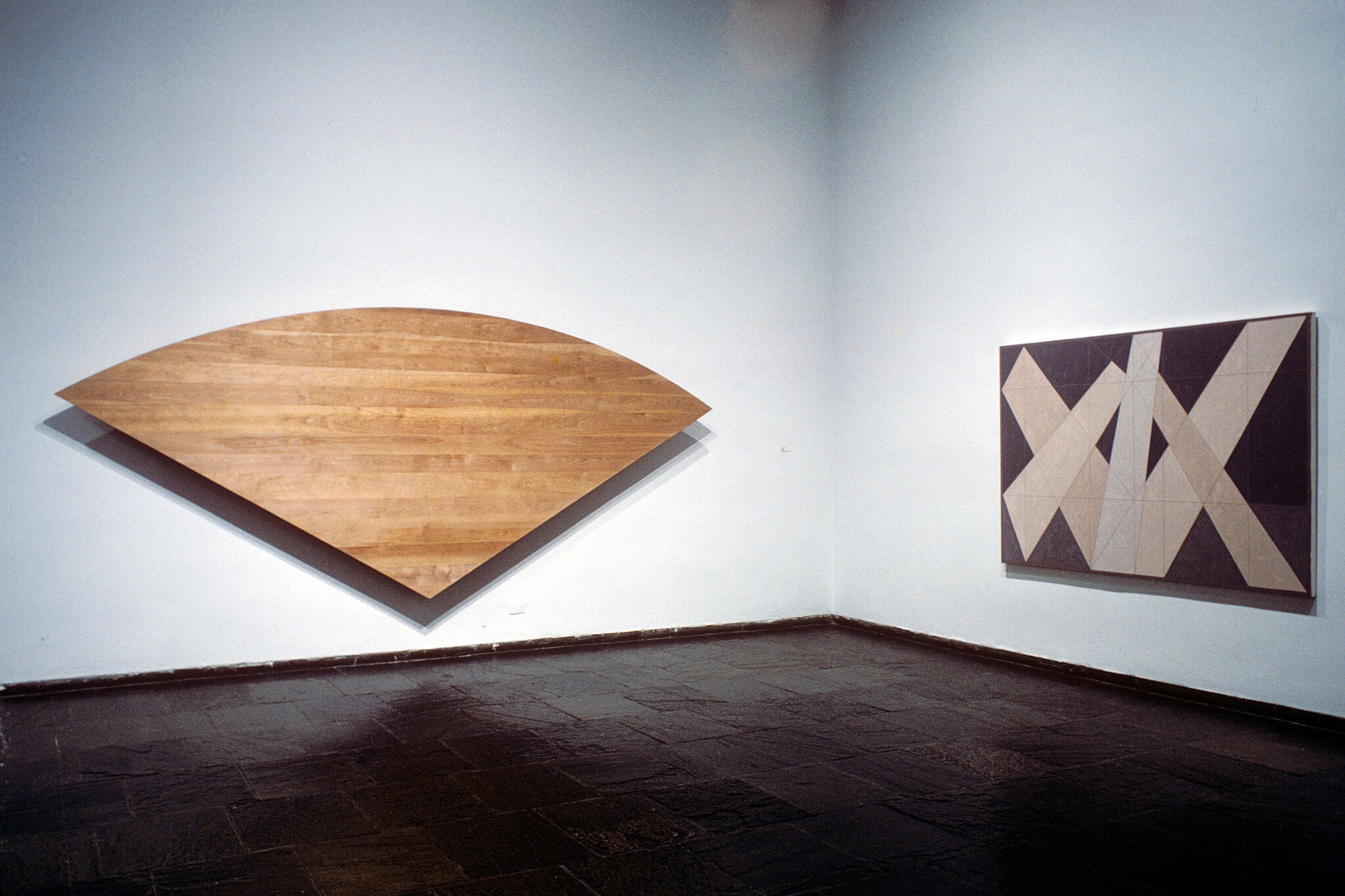 Two works of art hanging in a gallery.