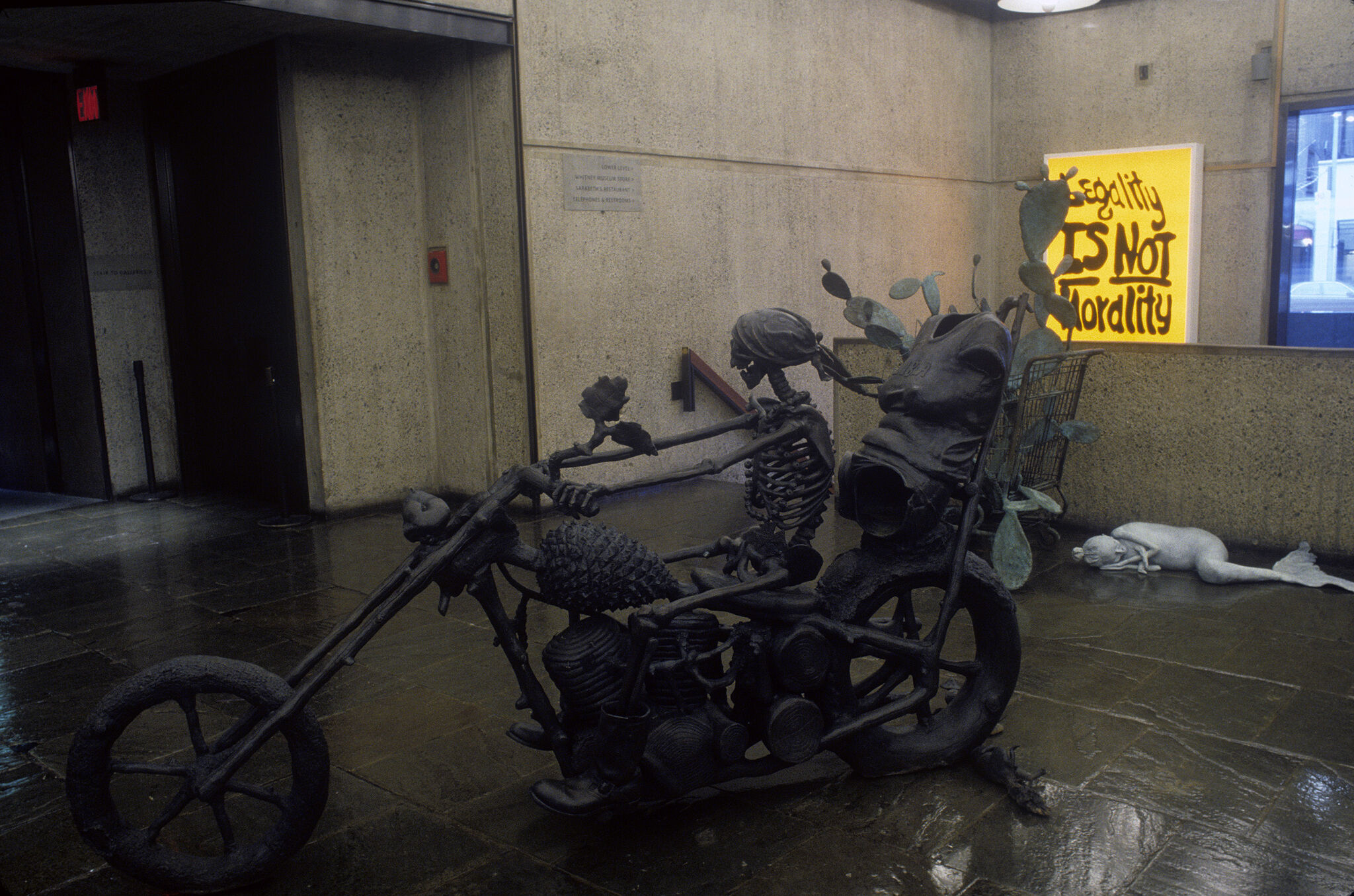 A sculpture of a skeleton on a bike.