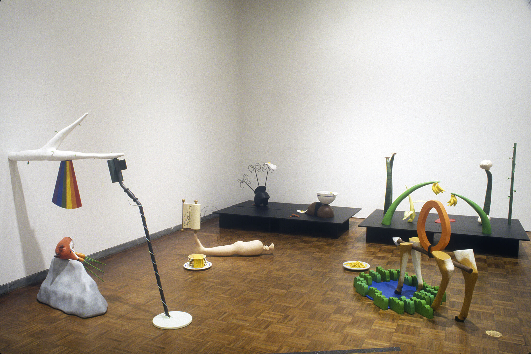 Various sculptures displayed on the floor of a gallery.