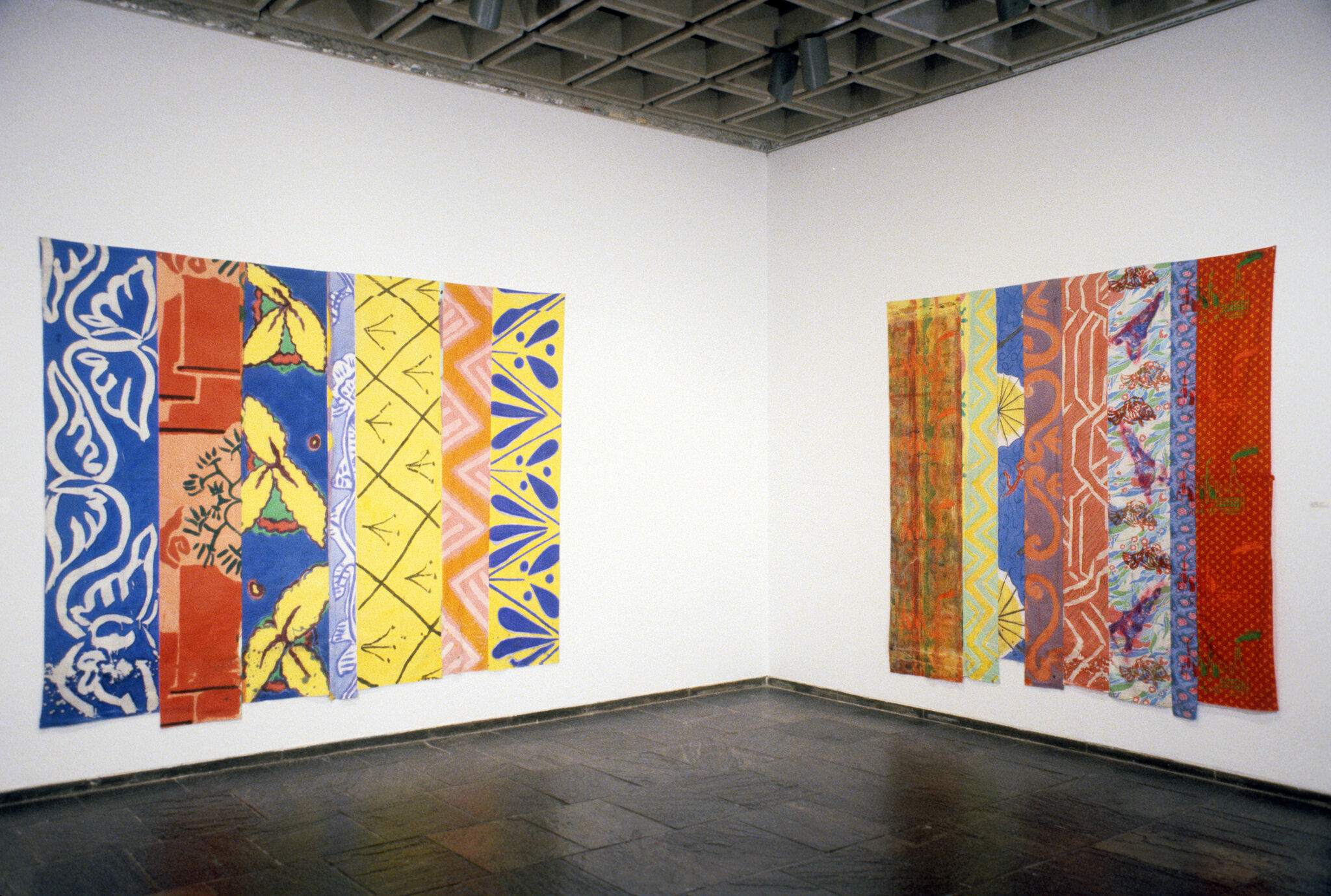 Two paintings hanging in a gallery.