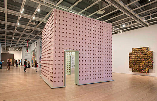 Structure made from four walls covered in grid pattern of bologna.