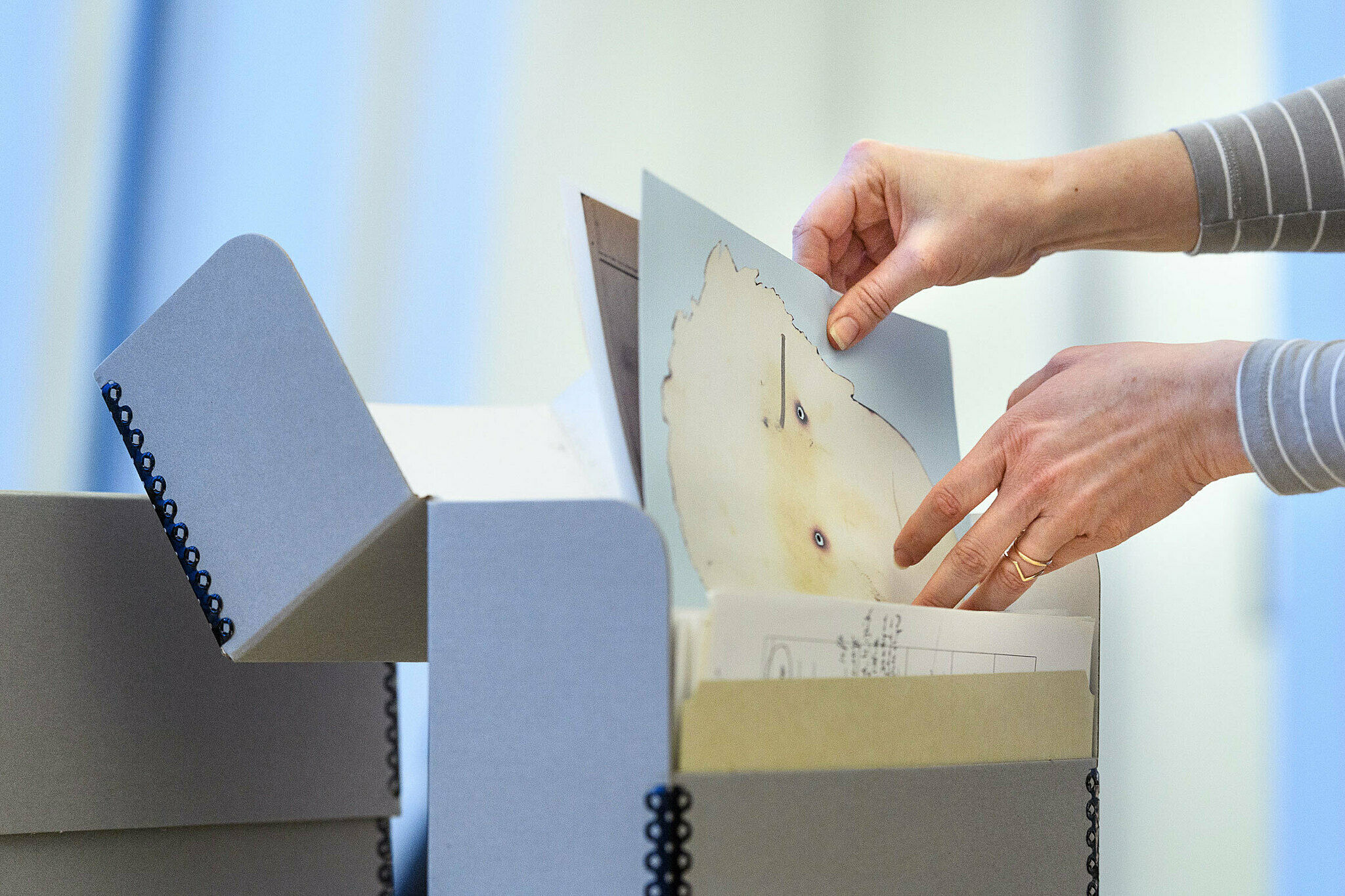 Flipping through artwork from a large folder.