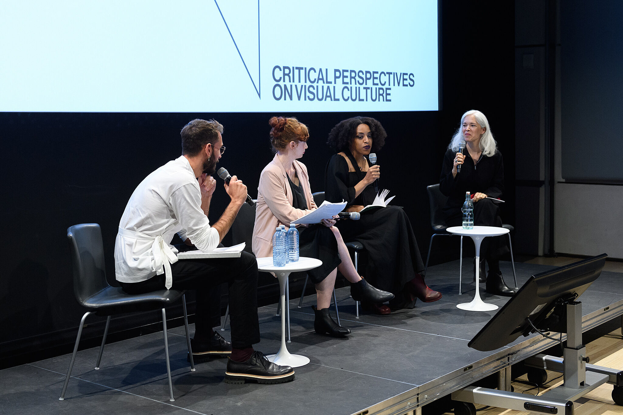 Four people sit on stage and engage in conversation.