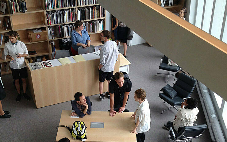 Artist Kate Hardy sits at a library table with curator Jay Sanders