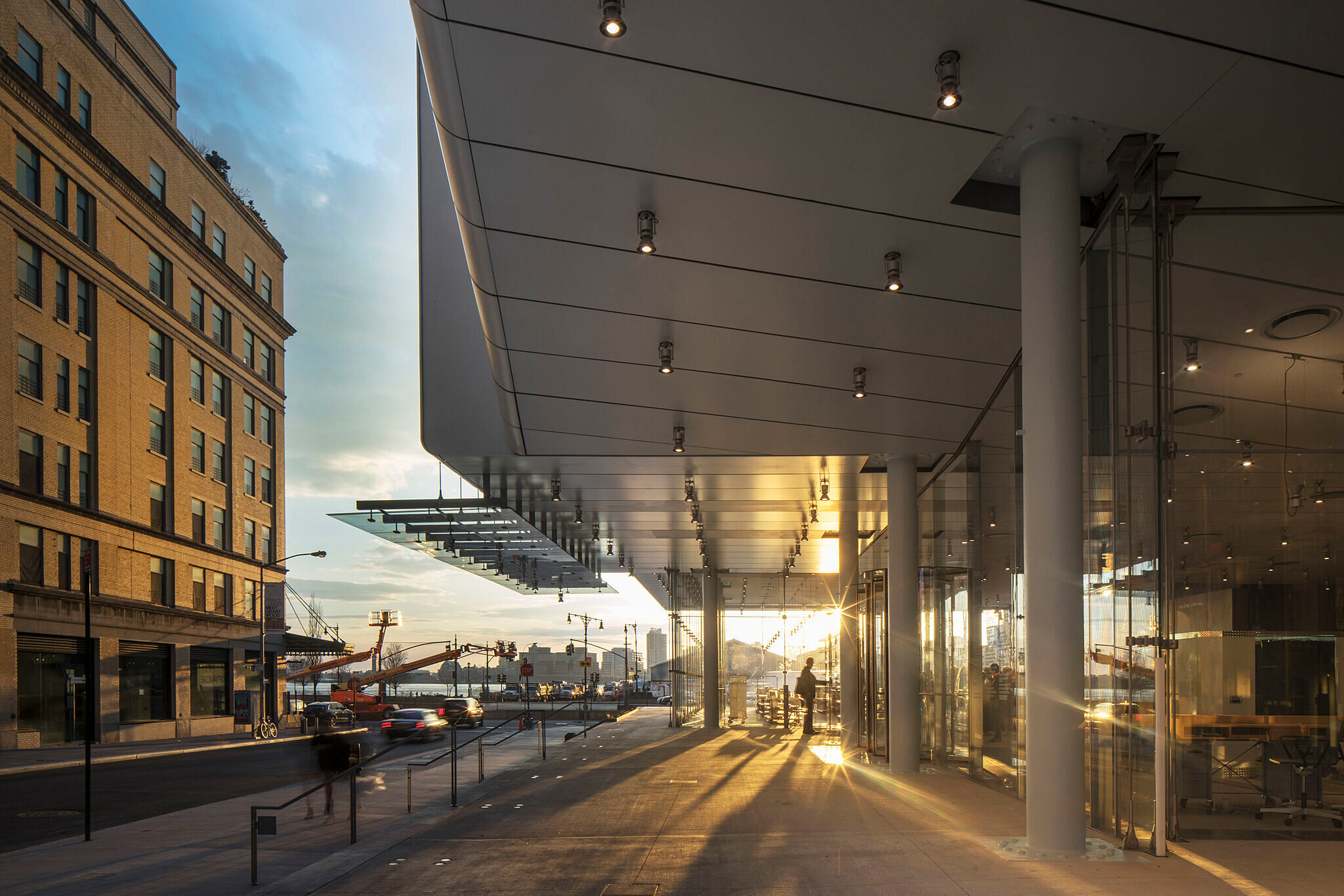 The sun sets behind the Whitney Museum and Hudson River. 