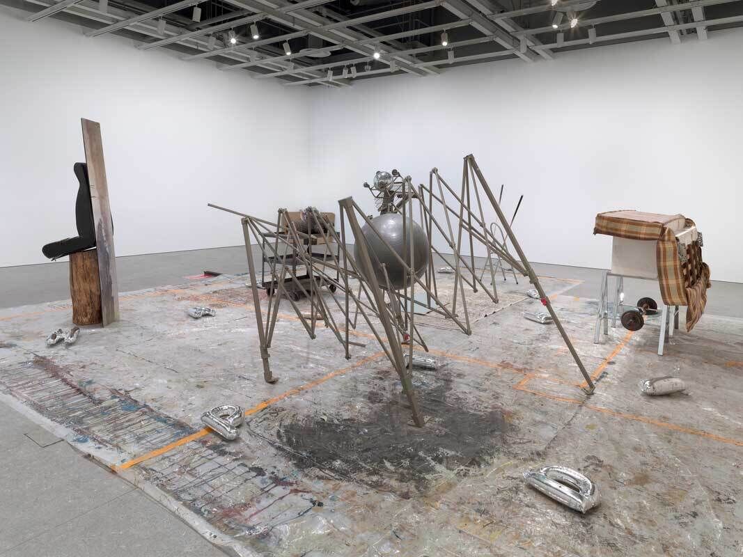 Gallery space with white walls filled with several sculptural assemblages made of a variety of discarded materials. 