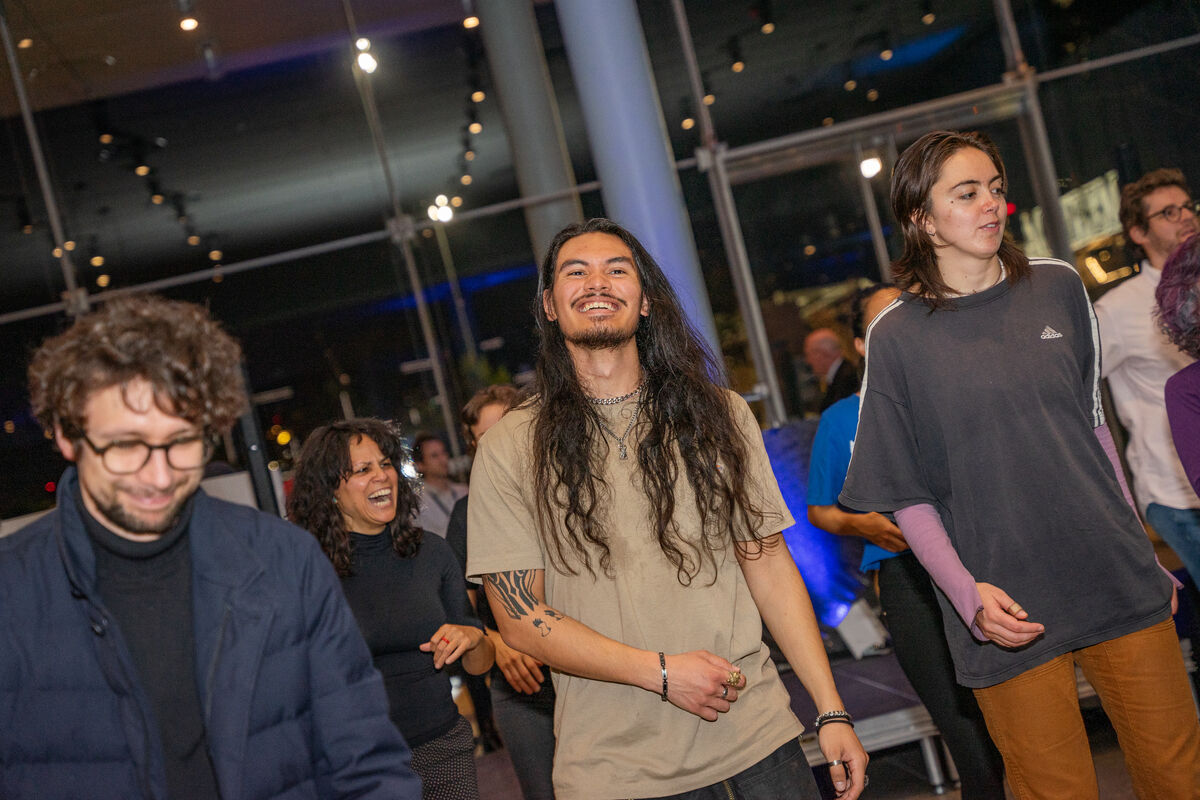 People dancing and smiling in the Museum's lobby 