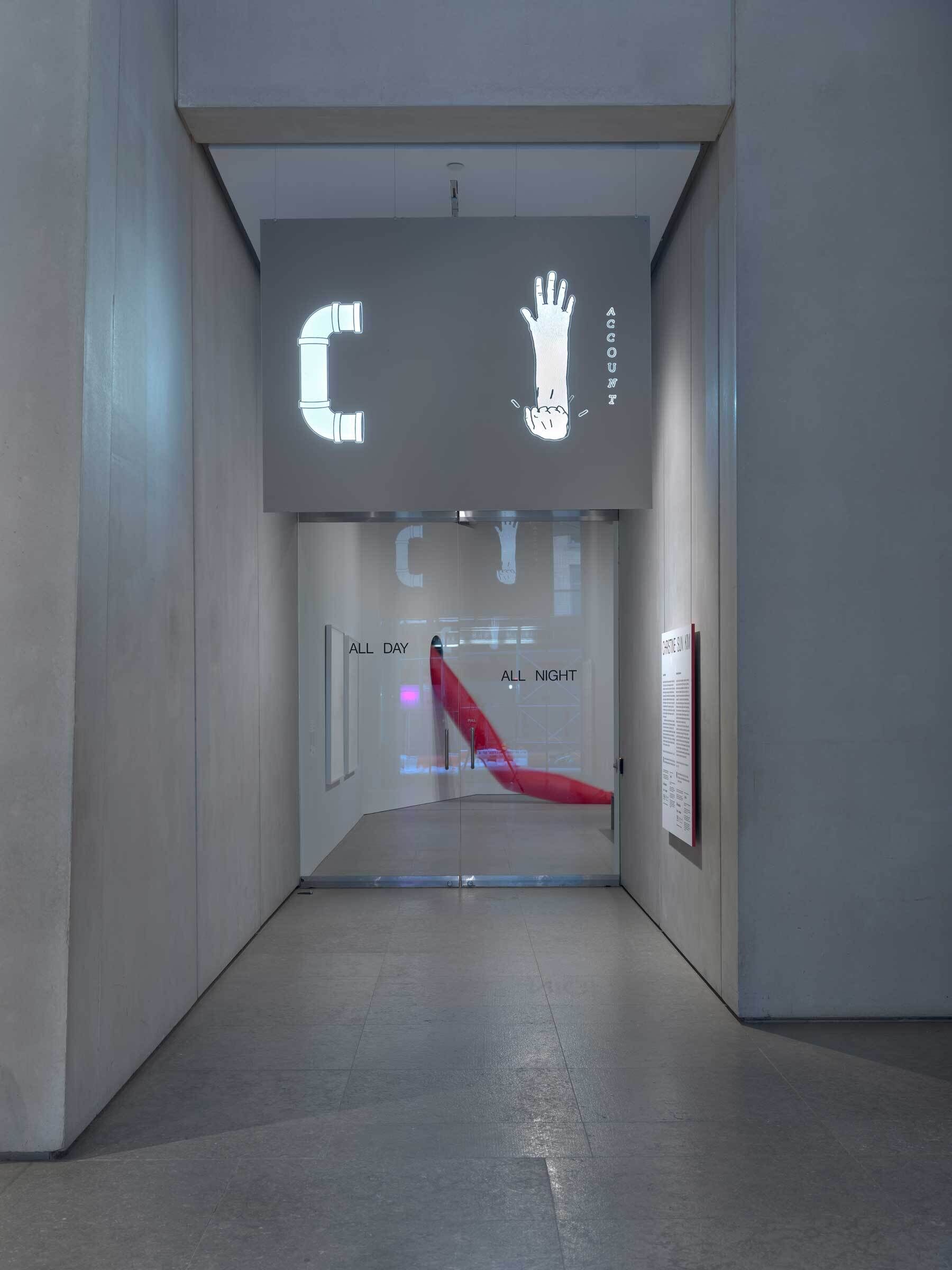 Hallway with a sign showing a pipe and hand, text reads "ALL DAY ALL NIGHT."