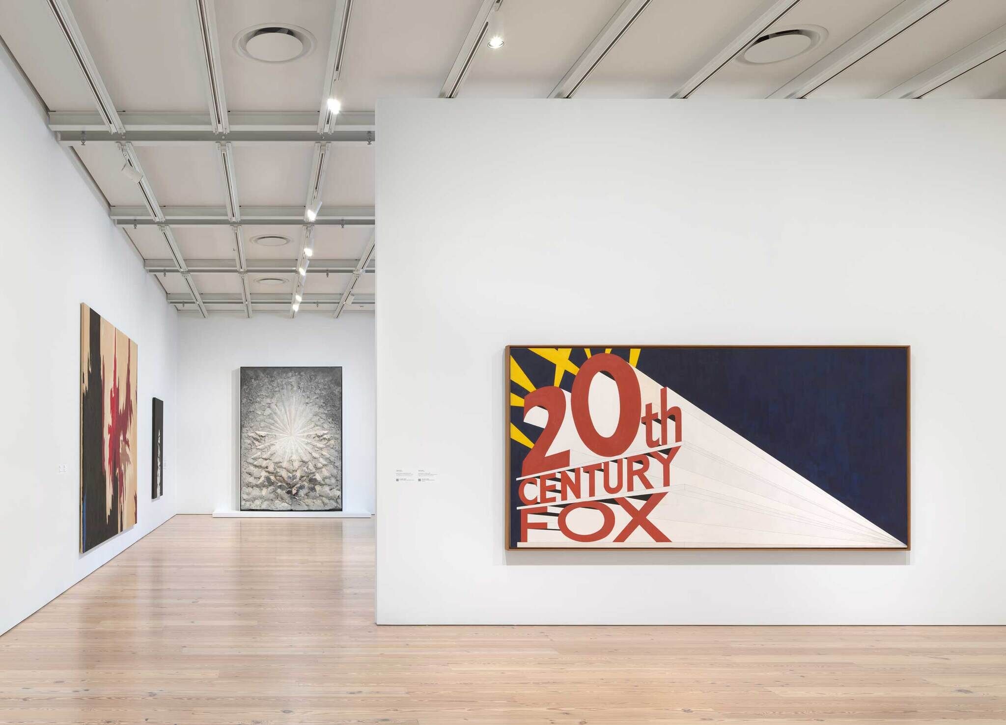 Large painting with the words "20th Century Fox" in bold letters displayed on a white gallery wall.