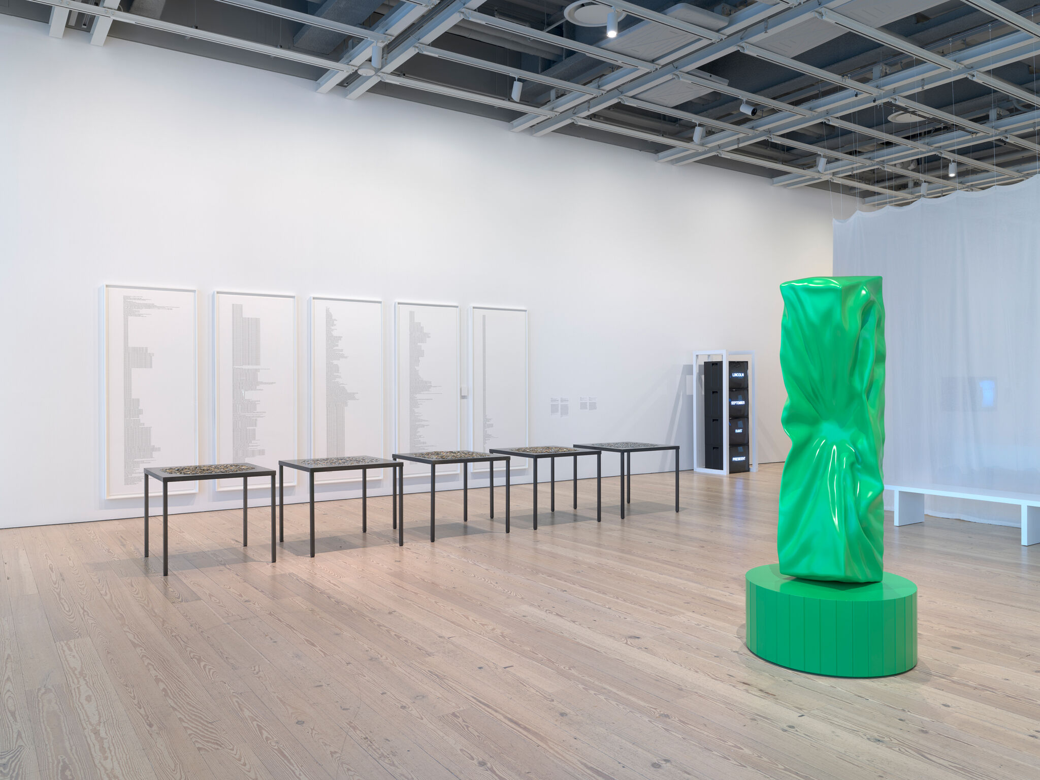 Three artworks in a a light-filled gallery.